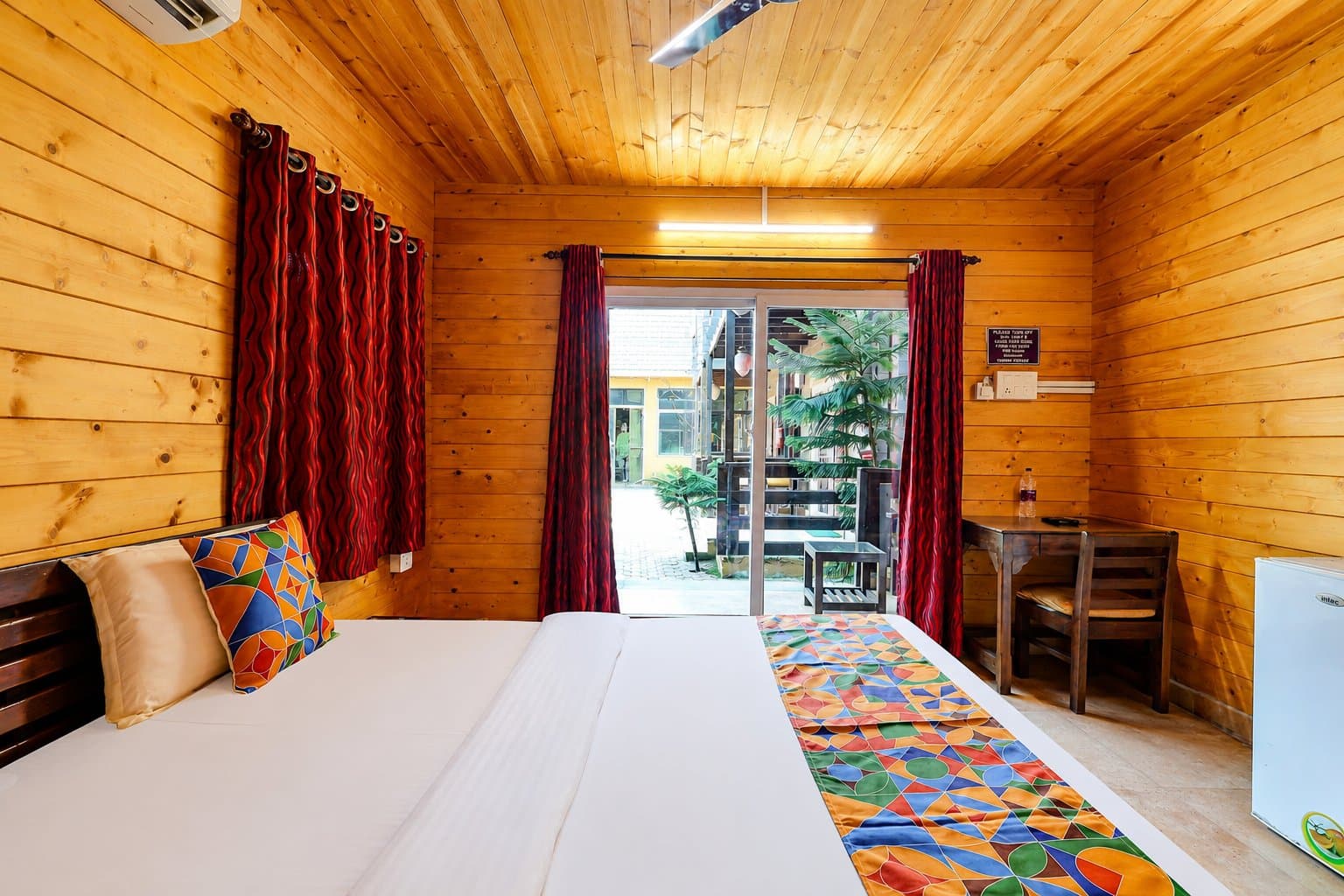 Deluxe Cottage — teak interiors opening to the garden